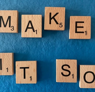 Scrabble tiles spelling out the words make it so on a blue background