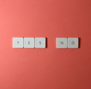 White tiles similar to scrabble tiles spelling out the words yes and no on a red background