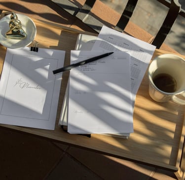 a notebook, pen and tea sit on a wooden platter