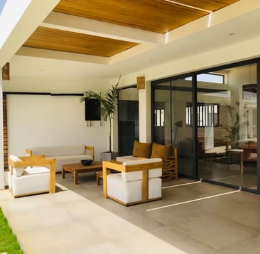 a patio with a couch and chairs and a television