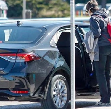 Una mujer subiendose a un coche VTC de Uber