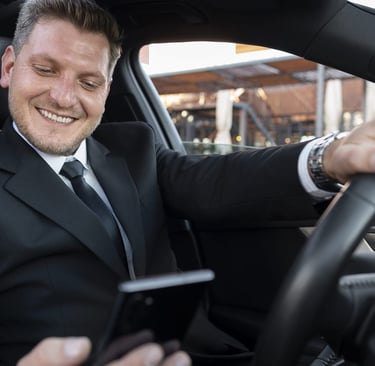 onductor VTC sonriendo mientras revisa su móvil dentro de un coche moderno.