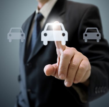 Hombre de negocios seleccionando un coche virtual en una pantalla, representando seguros VTC baratos