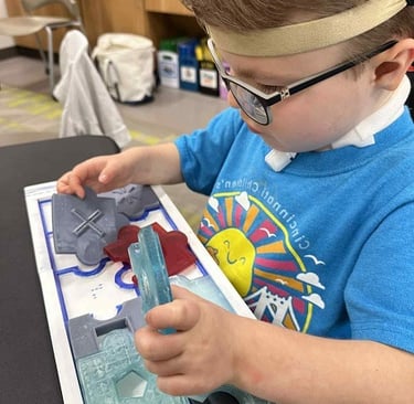 Child exploring a tactile puzzle by DUAL Tools, building sensory and problem-solving skills