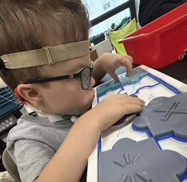 DeafBlind learner focuses on tactile puzzle provided by DUAL Tools Initiative