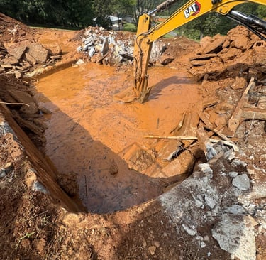 excavator digging out concrete pool