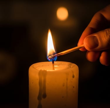 Close-up of a hand striking a match to light a candle