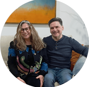 a man and woman sitting on a couch smiling