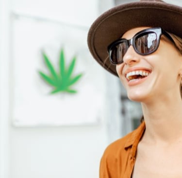 a woman in a hat and sunglasses smiling