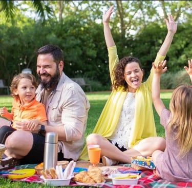 a family of four people sitting on a blanket