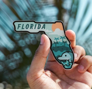 a person holding a florida state shaped sticker