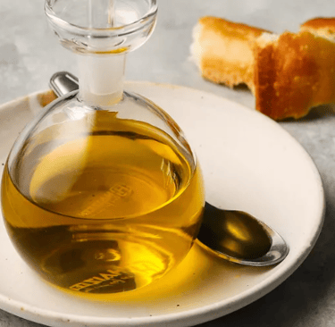 a bottle of olive oil on a plate with bread and bread