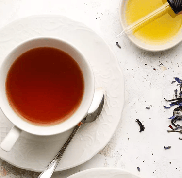 a cup of tea and a spoon on a plate