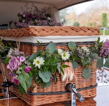 Wicker funeral casket decorated with fresh flowers
