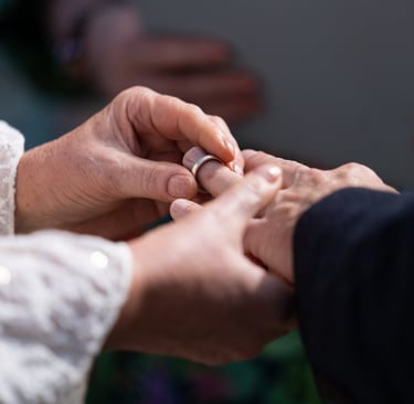 Bride placing a wedding ring on a groom's finger