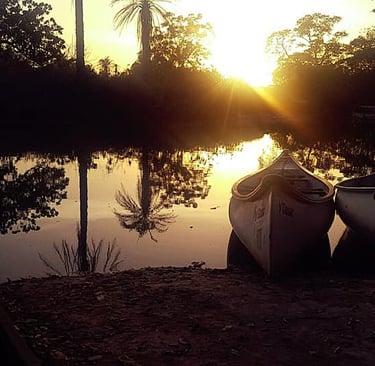 A tranquil view of the Marakissa River Camp, showcasing safari-style tents and rustic cabins situate