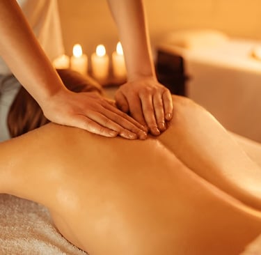 Therapist performing unisex body massage at spa