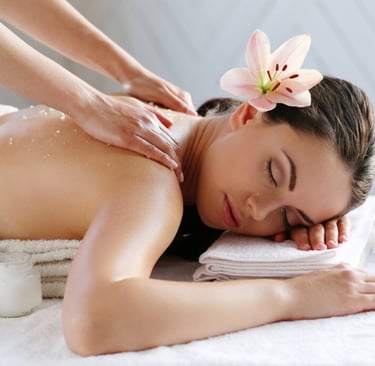 Therapist performing unisex body massage at spa