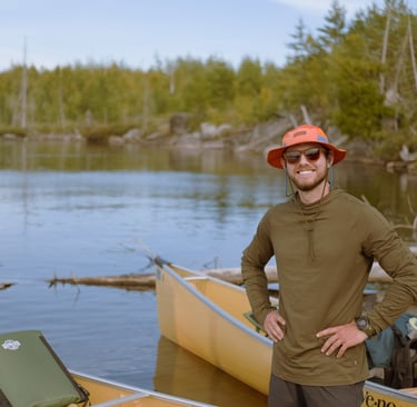 Nate Bowery standing in front of canoe while canoeing the Boundary Waters in Minnesota