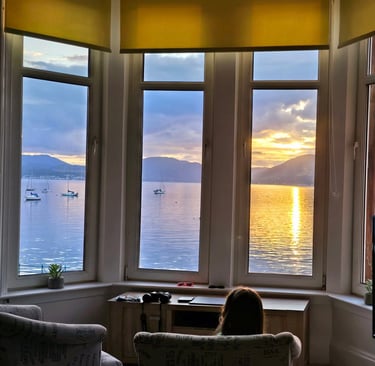 a girl sitting in a chair looking out at the ocean at Gourock Seaview Holiday Let