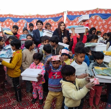 Volunteers distributing charity donation boxes and clothes to underprivileged children at a community event.