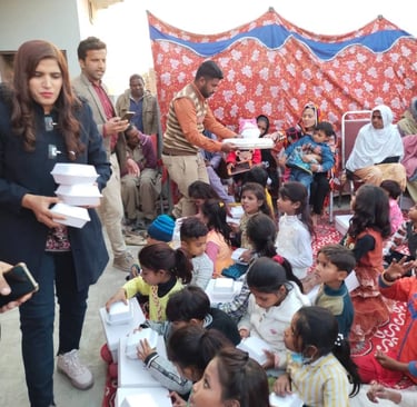 Volunteers distributing boxed meals to a group of children at a community charity event.
