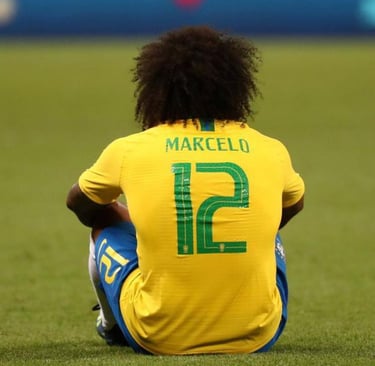 a soccer player sitting on the ground with his foot on the ground