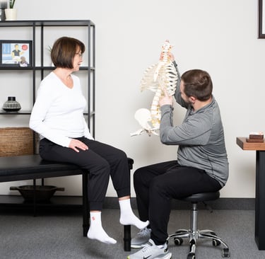 Osteopathic practitioner educating the patient on the spine  