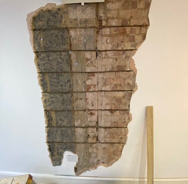 An exposed brick wall showing structural reinforcement with steel mesh and wall ties during home renovation.