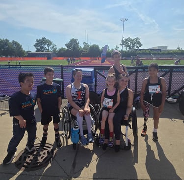 GLASA Team Athletes sitting and standing with a racing track in the background