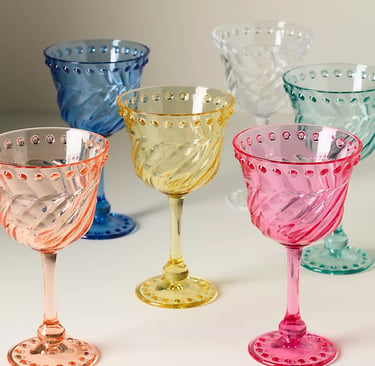 Elegant set of colorful hobnail wine glasses with swirl patterns in pink, yellow, blue, and teal.