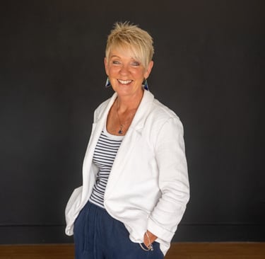 a business headshot woman in a white jacket and blue pants