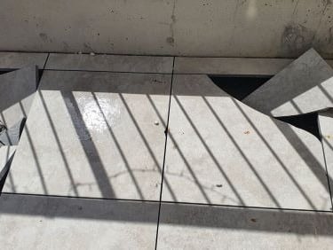 Pedestal tiles broken by small pebbles dropped by birds