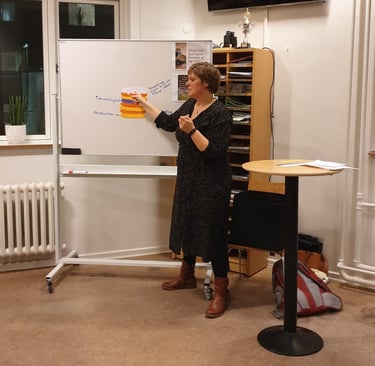 Billede af Gunda som holder oplæg og forklarer noget på en tavle.