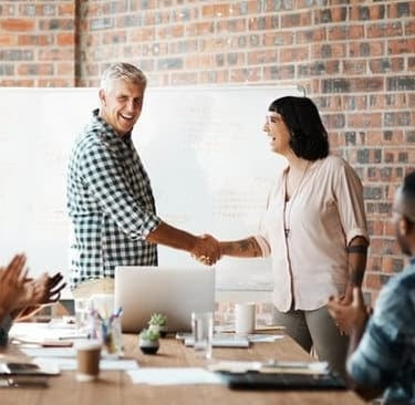 Happy colleagues shaking hands