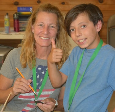 a woman and a boy having fun at crafts