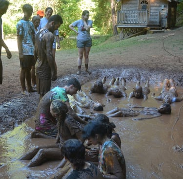 a group of people standing around a muddy puddle