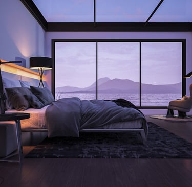 Modern bedroom with large bed, floor-to-ceiling windows, and view of lake and mountains.