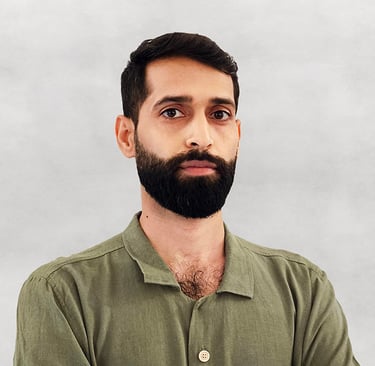 Portrait of VISUALISE founder in green shirt, light gray background.