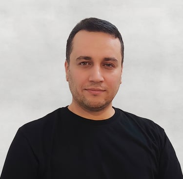 Portrait of a VISUALISE team member, black T-shirt, with a plain neutral background.