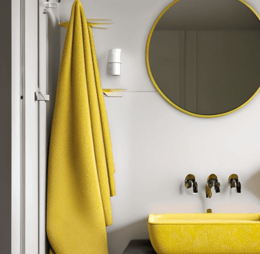 a bathroom with a yellow sink and yellow and white towels