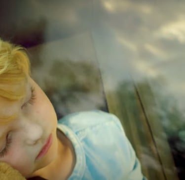 a young boy is holding a teddy bear