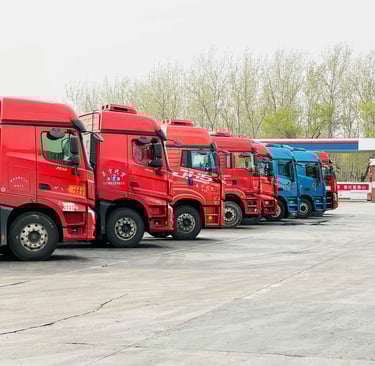 Red and Blue Trucks Parked at a Depot
