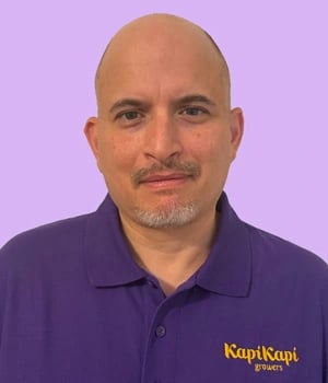 a man in a purple shirt and a purple shirt with kapi kapi growers logo