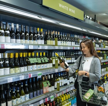 a woman is shopping in a store with a shopping carton