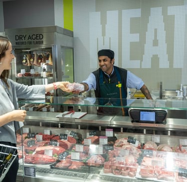 a man and woman in a butcher shop