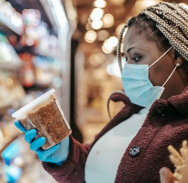 changing frozen food trends; a woman in a mask and gloves holding a piece of bread