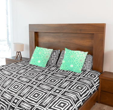 Bed with throw pillows and a duvet cover on it