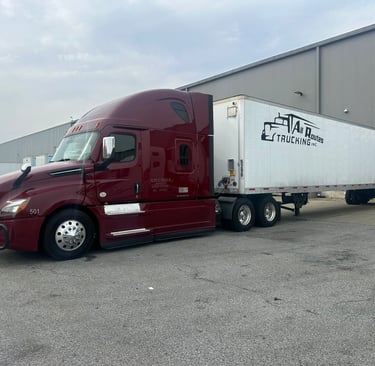 a semi truck with a trailer parked in front of a building