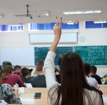 a woman raising her hand up in a classroom